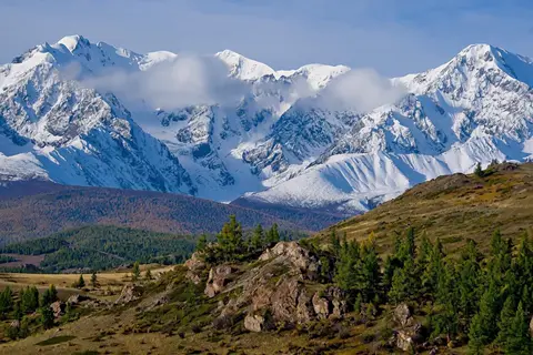 Hailuo H3 clip: snow-covered mountain range above larch-covered hills in the Altai