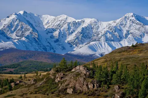 Kling 3.0 clip: snow-covered mountain range above larch-covered hills in the Altai