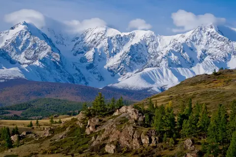 PixVerse V6 clip: snow-covered mountain range above larch-covered hills in the Altai