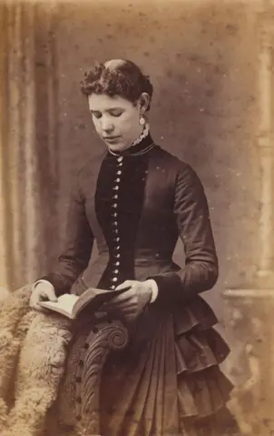 Kling 3.0 clip: sepia cabinet card of a Victorian woman holding a book