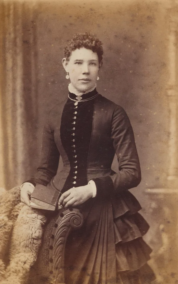 Sepia cabinet card of a Victorian woman holding a book