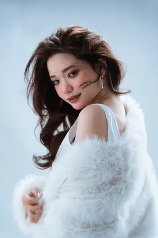 Kling 3.0 clip: studio portrait of a woman in a white fur wrap looking back over her shoulder